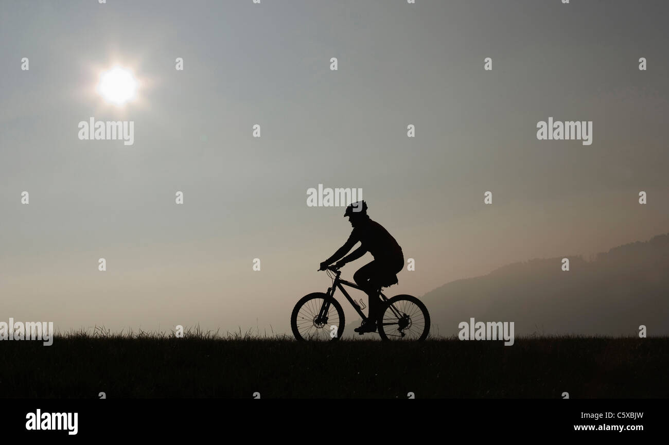 Mann reitet ein Mountain-Bike, Twilight, silhouette Stockfoto
