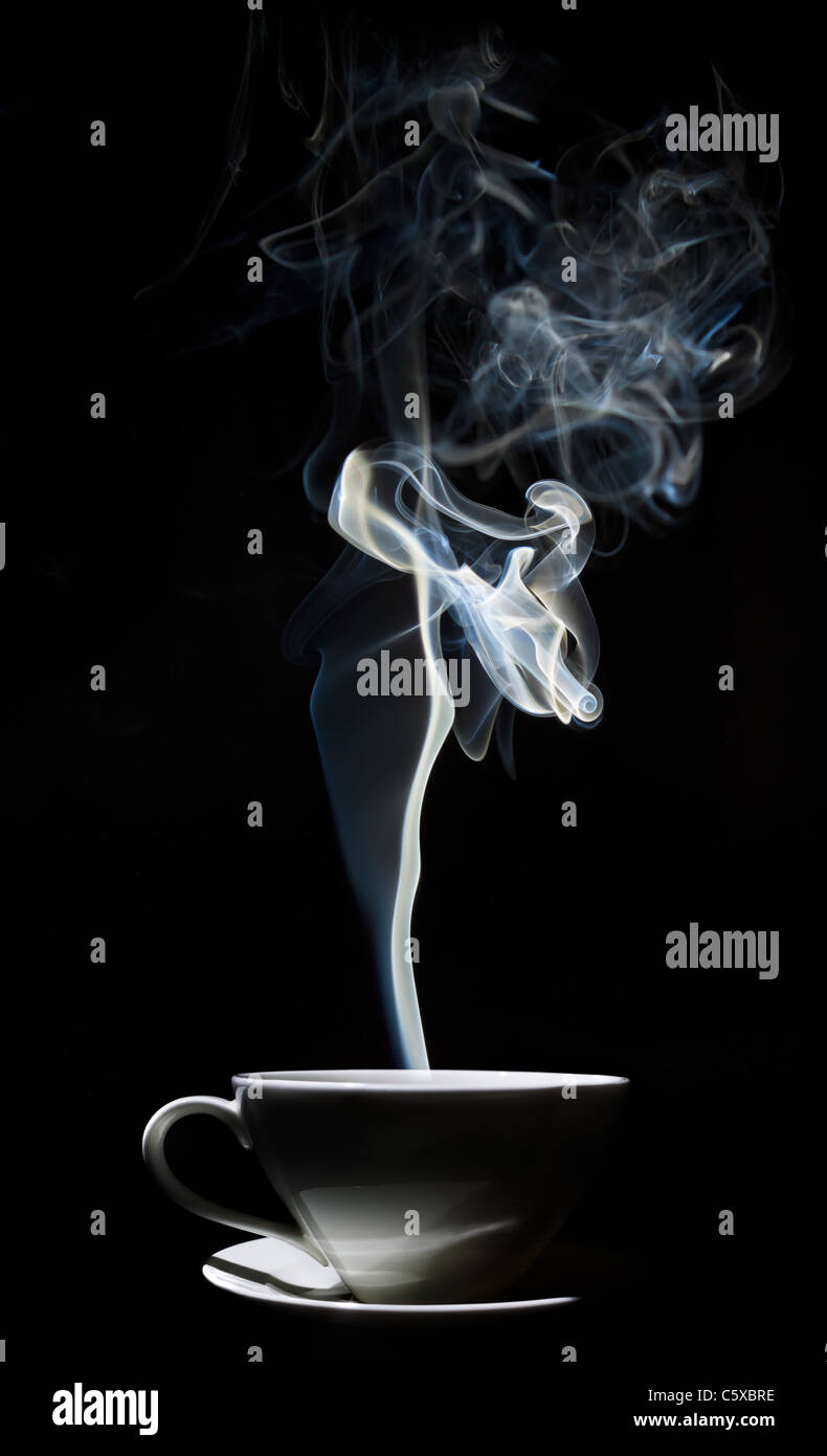 Weiße Tasse Kaffee mit einem dichten Rauch in der Luft, vor einem schwarzen Hintergrund. Stockfoto