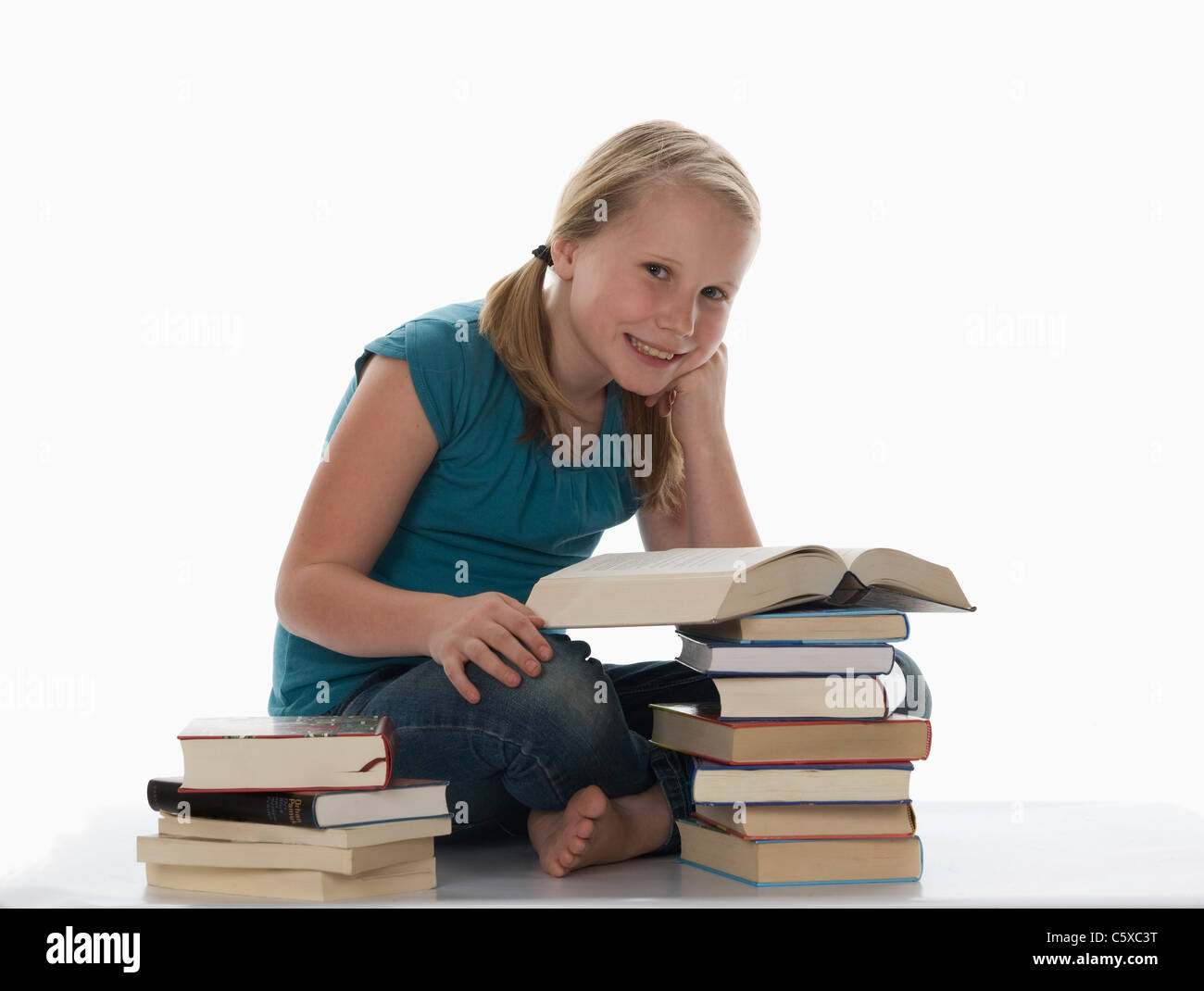Porträt eines Mädchens (10-11) und gestapelte Bücher Stockfoto