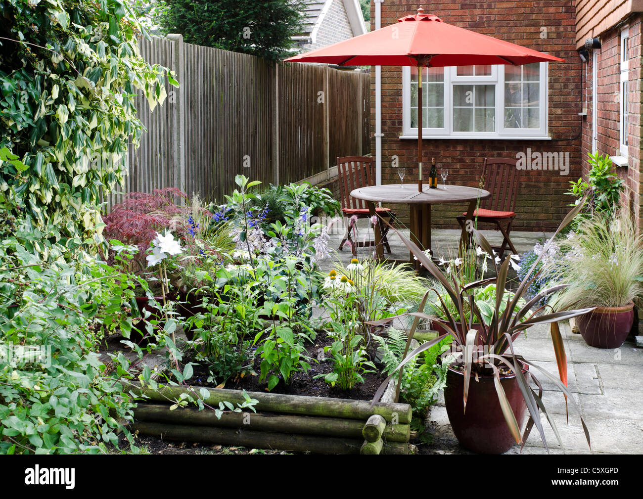 Terrasse Gartentisch Stühle und Sonnenschirm Surrey Stockfoto