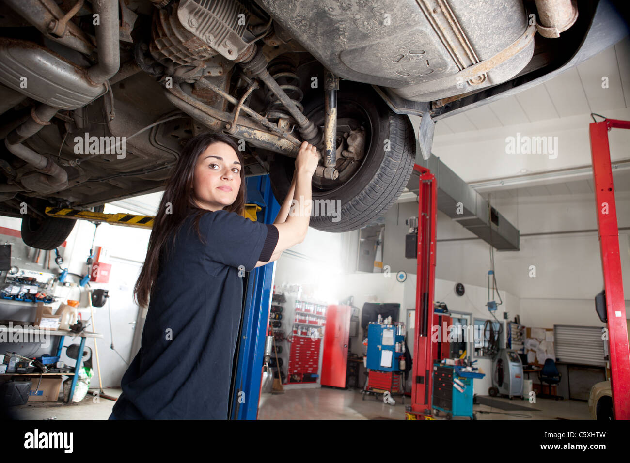 Porträt der Frau Mechaniker arbeiten an der Unterseite eines Autos Stockfoto