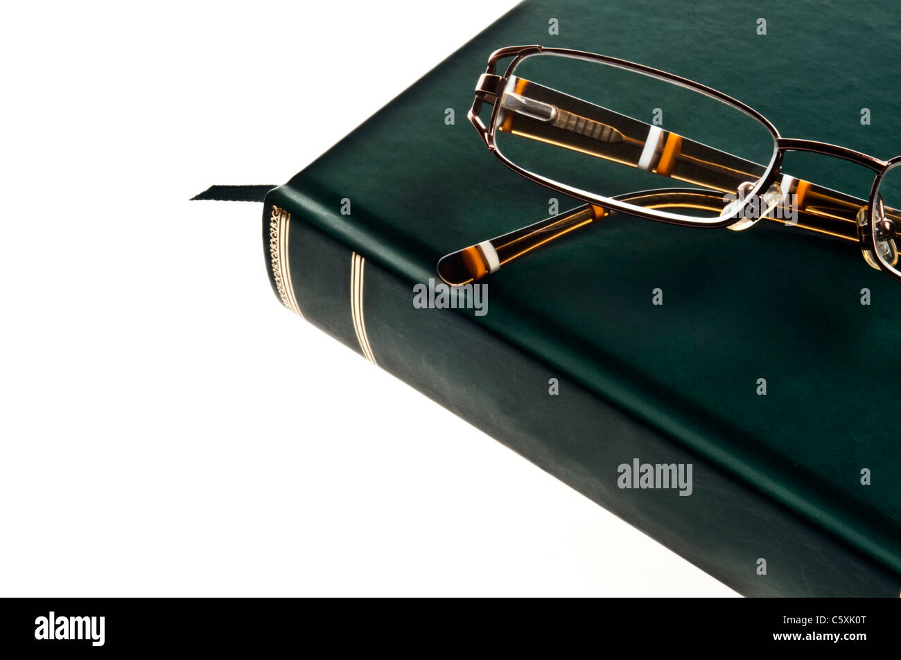 Isolierte grünes Buch und Brille Stockfoto