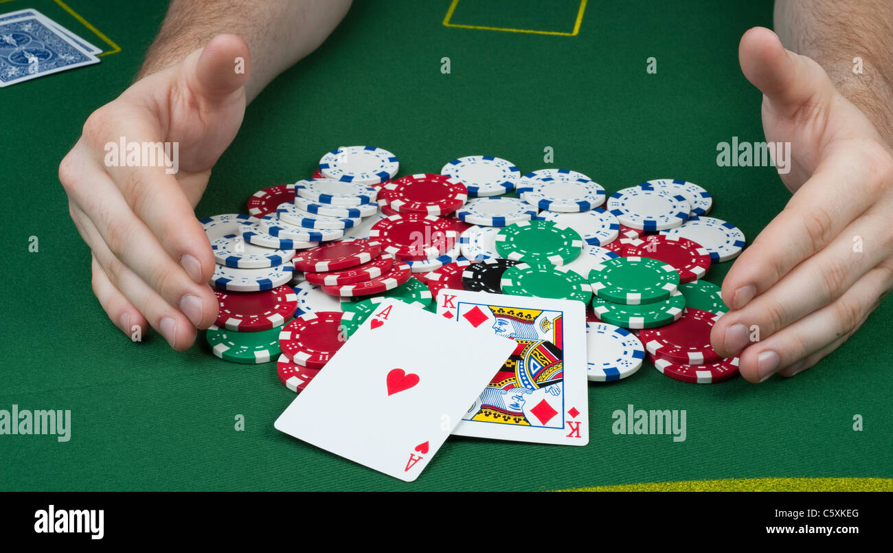 Regale die Hände einer ein Haufen von Poker chips mit einem Ass König Stockfoto