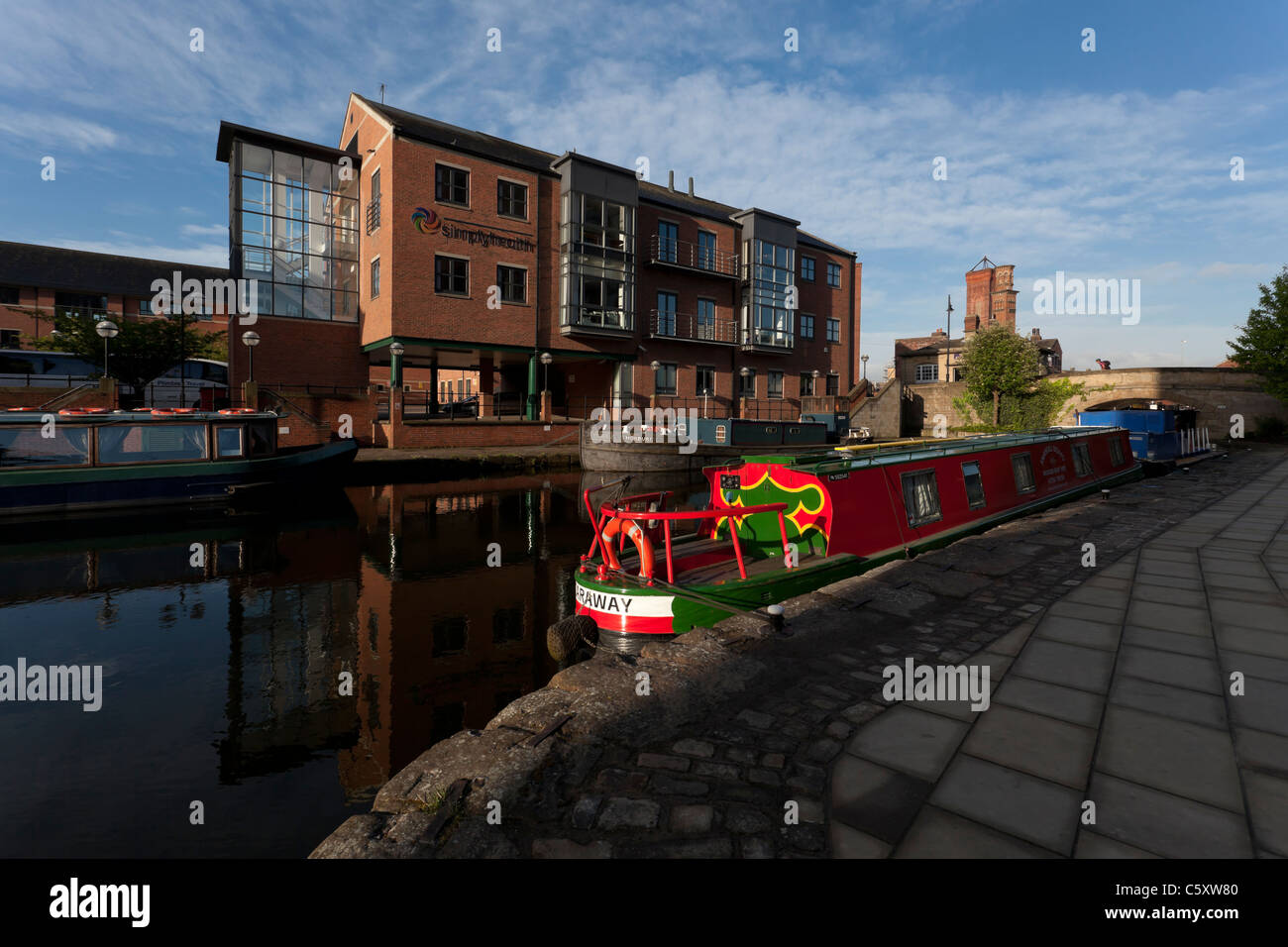 Moderne Gebäude durch den Fluss Aire in Leeds, Teil der Uferpromenade-Sanierung. Stockfoto