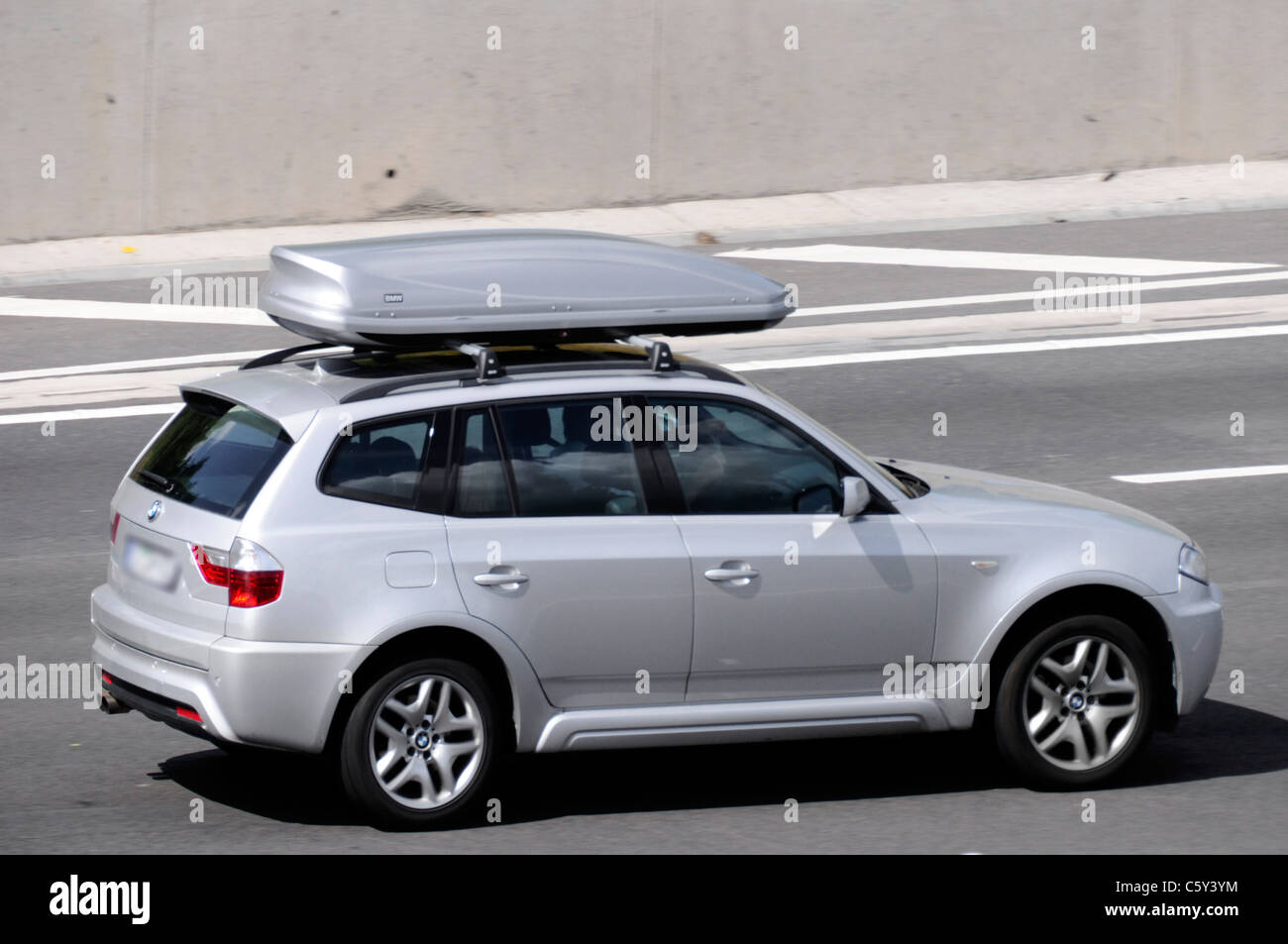 Transport über silbernen BMW Auto mit passenden BMW Koffer Box (verdeckt Nummernschild) de Autobahn entlang fahren Stockfoto