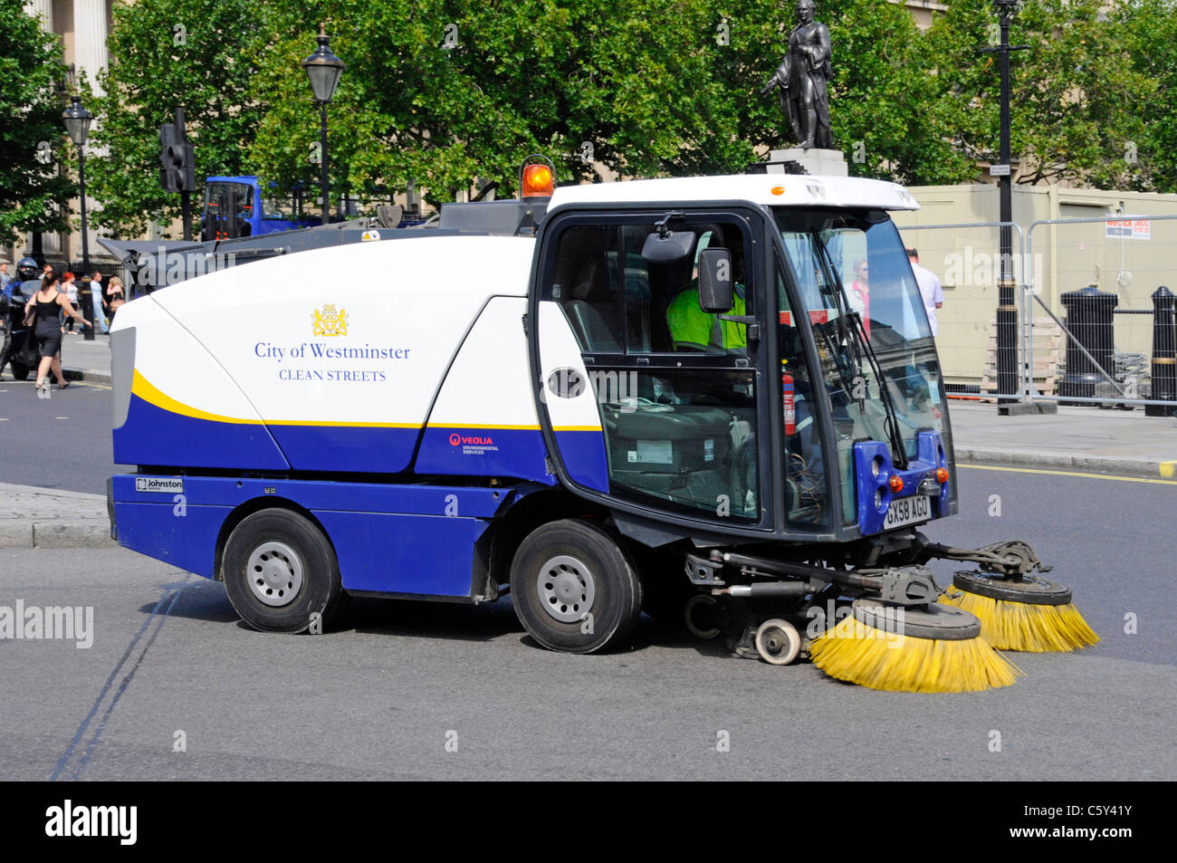 Straßenarbeiter in London, der eine Straßenreinigungsmaschine fährt, die von Veolia Environmental Services für die City of Westminster council England UK betrieben wird Stockfoto