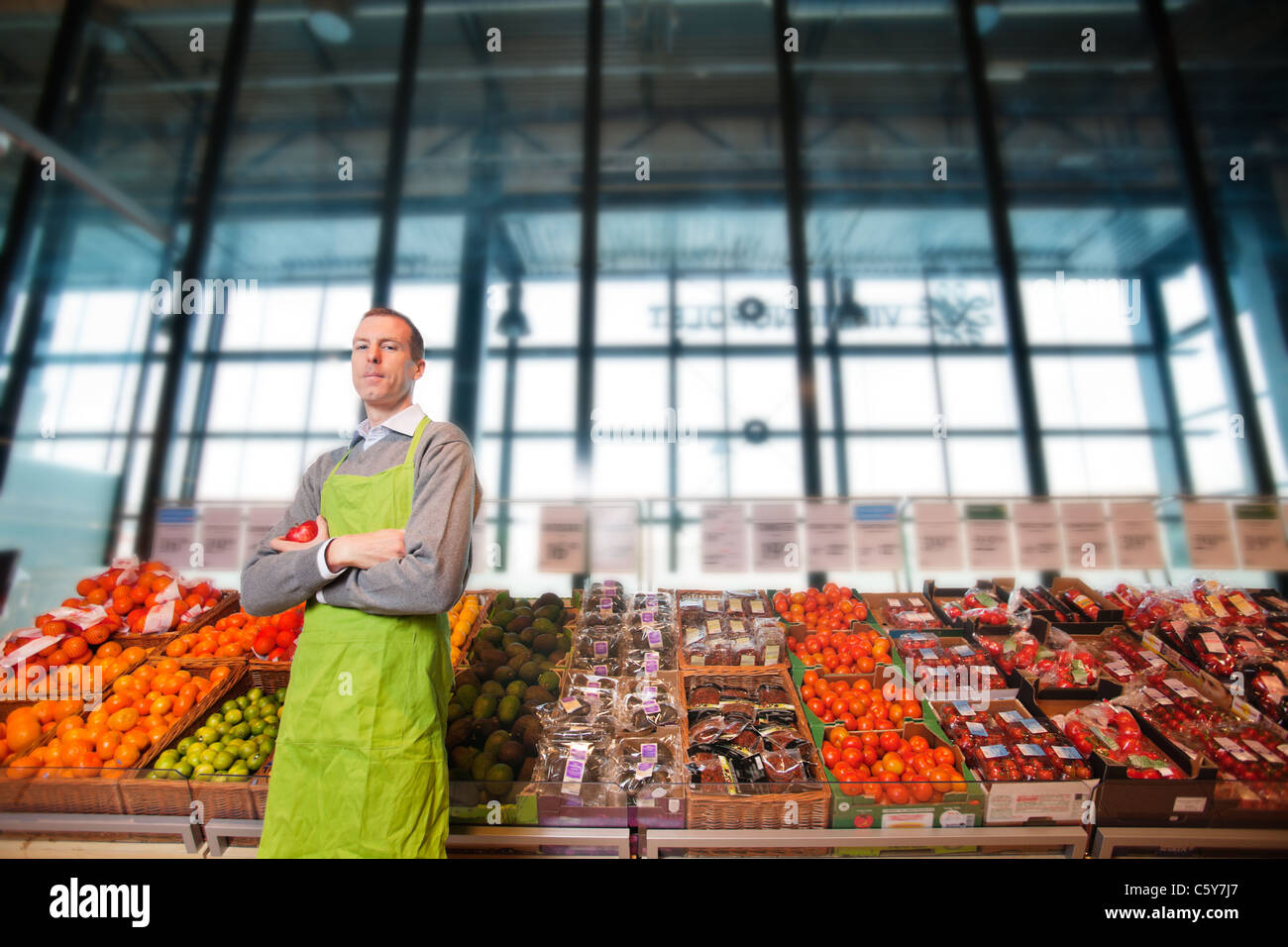Porträt eines Lebensmittelgeschäft Clkerk oder Eigentümer vor einem Gemüsetheke Stockfoto