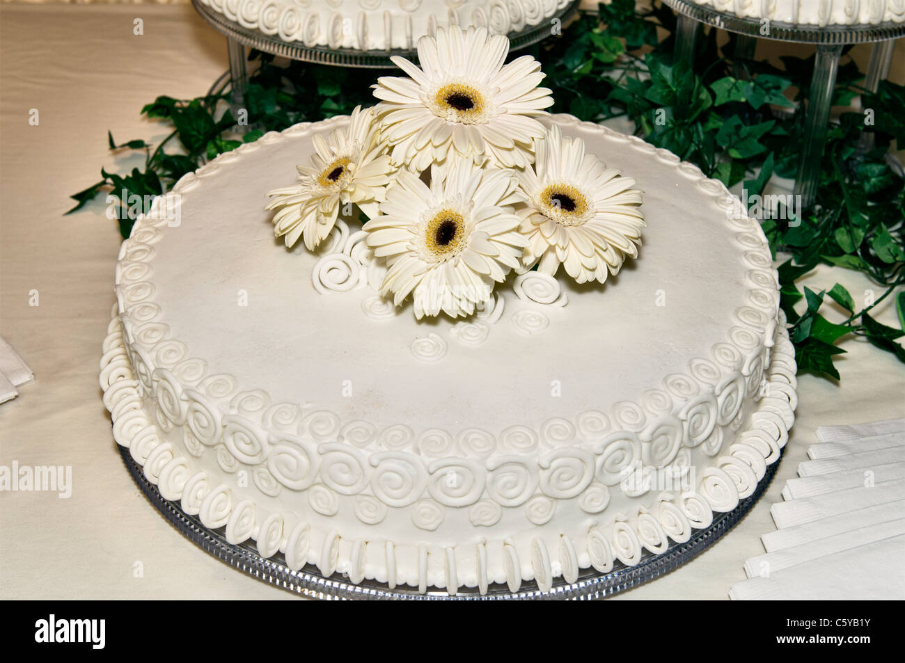 Nahaufnahme der wichtigsten Hochzeitstorte, dekoriert mit Blumen-weiße Gänseblümchen. USA Stockfoto