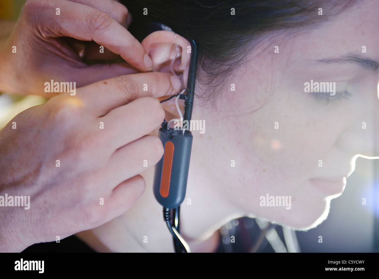 Junge weibliche Audiologie Schüler tragen ein Hörgerät Gerät für einen Test auf dem rechten Ohr Stockfoto