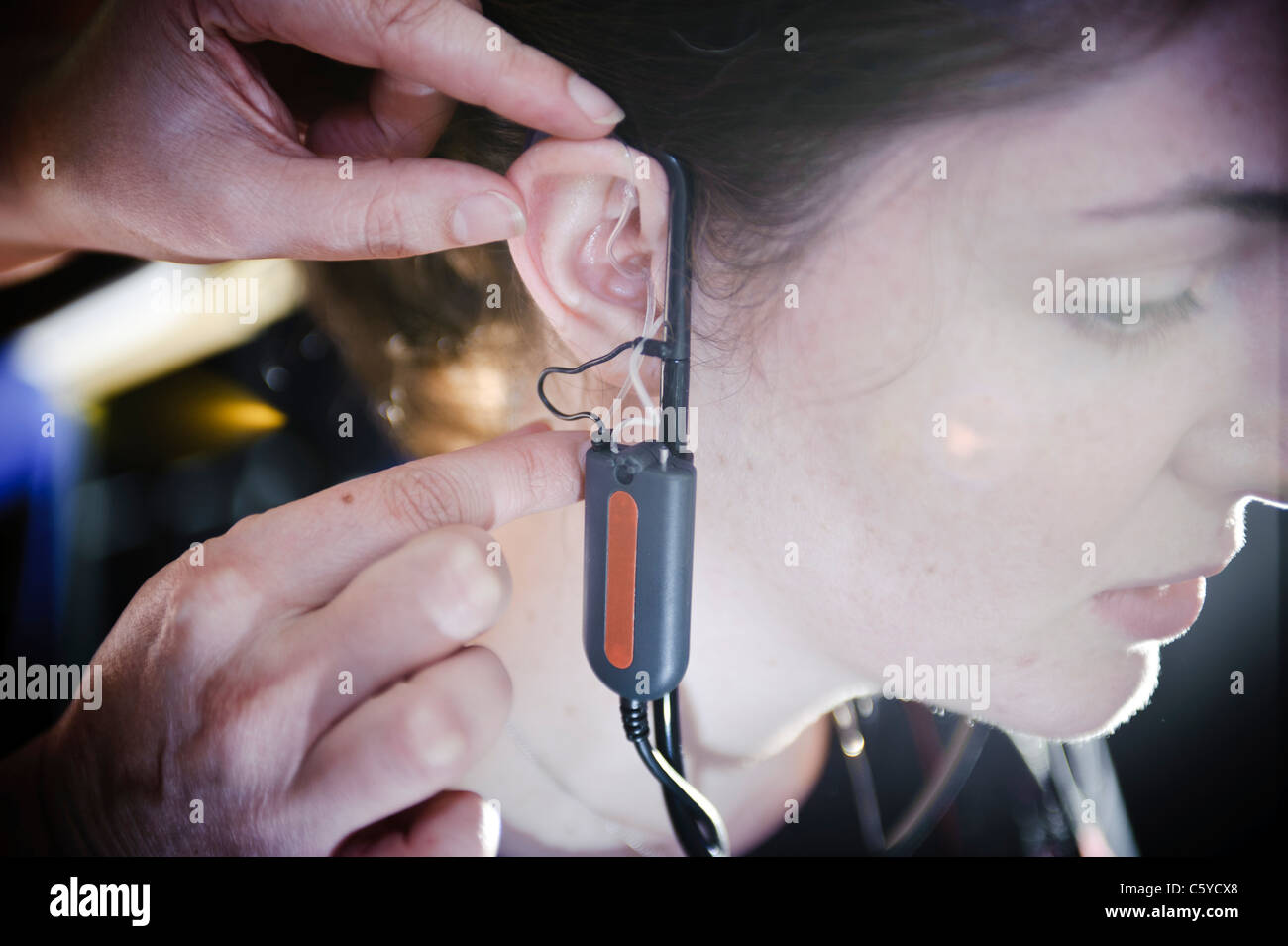 Junge weibliche Audiologie Schüler tragen ein Hörgerät Gerät für einen Test auf dem rechten Ohr Stockfoto