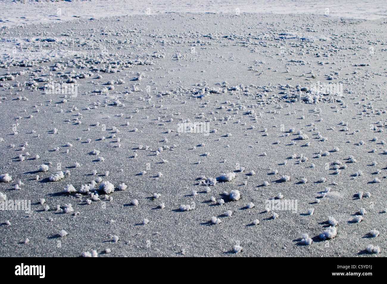 Schneebälle auf eine gefrorene Pfütze Stockfoto