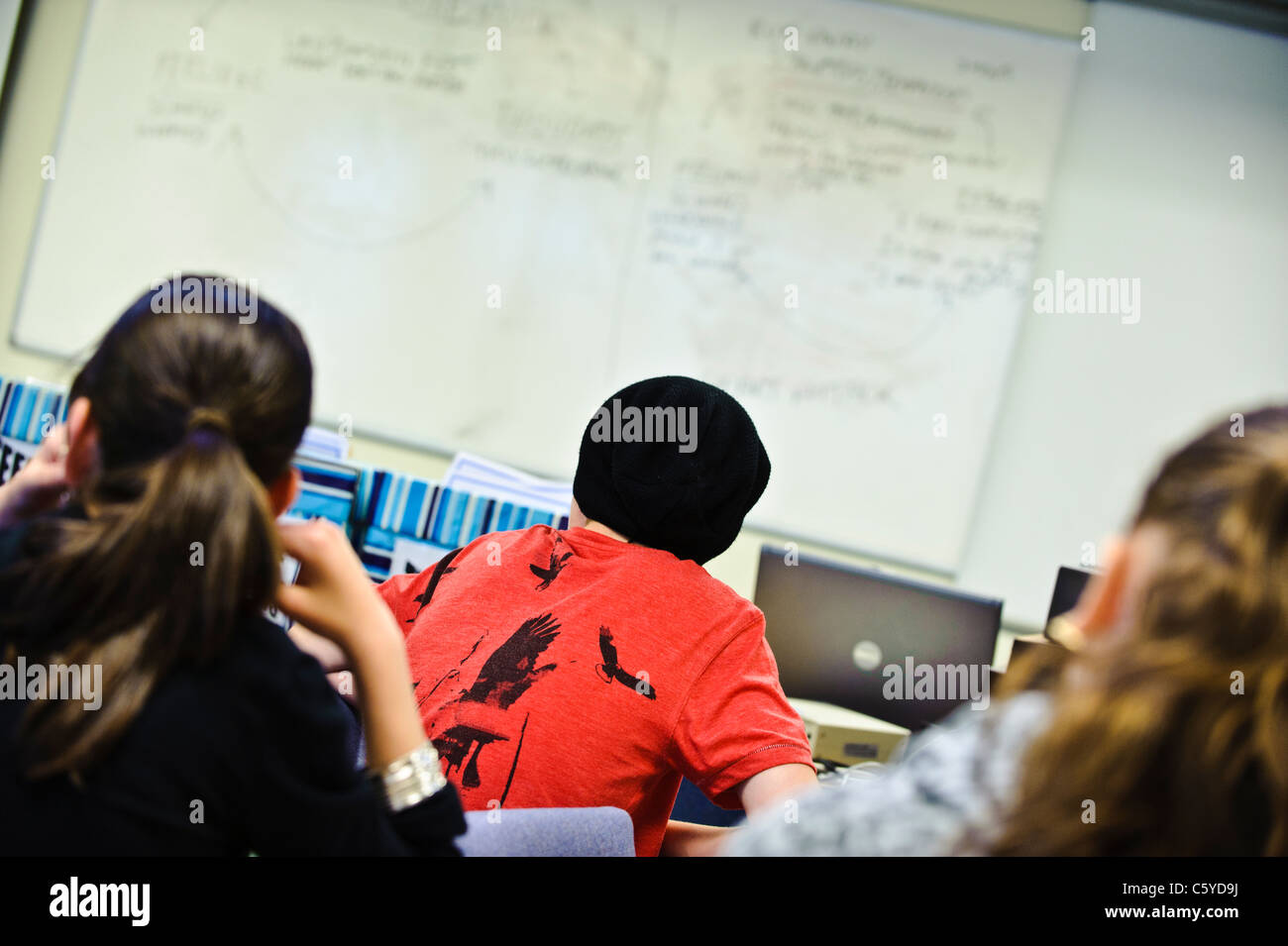 Schulkinder im Alter von 12-13 Jahre im Klassenzimmer Kamera hinter Rückseite Kopf Kinder zugewandten Whiteboard keine Flächen sichtbar Stockfoto