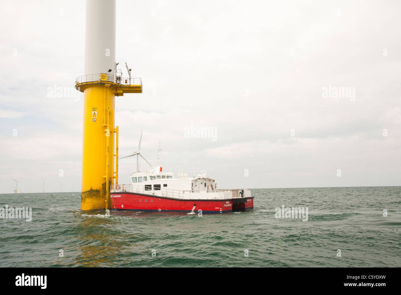 Ein Versorgungsschiff neben einer Windkraftanlage des Projekts Walney Offshore Windpark, aus Barrow in Furness, Cumbria, UK. Stockfoto