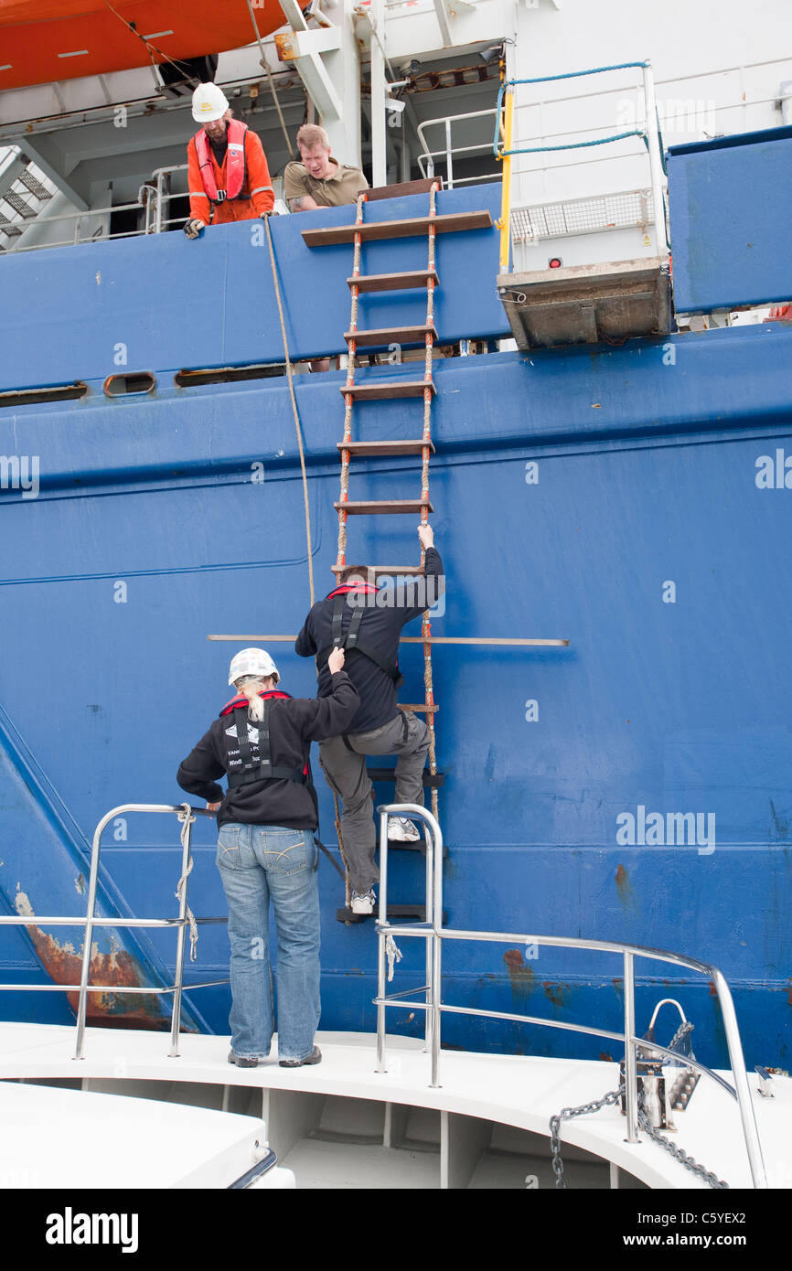 Wind Turbine Bauarbeiter aus einer Kabelverlegung Schiff zurück zum Ufer, Cumbria, England. Stockfoto