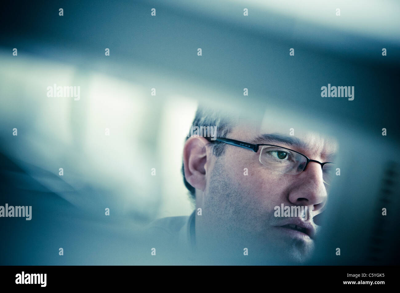 Nahaufnahme eines männlichen Wissenschaftler Gesicht mit Brille, die wissenschaftlichen Daten auf dem Computerbildschirm zu betrachten Stockfoto