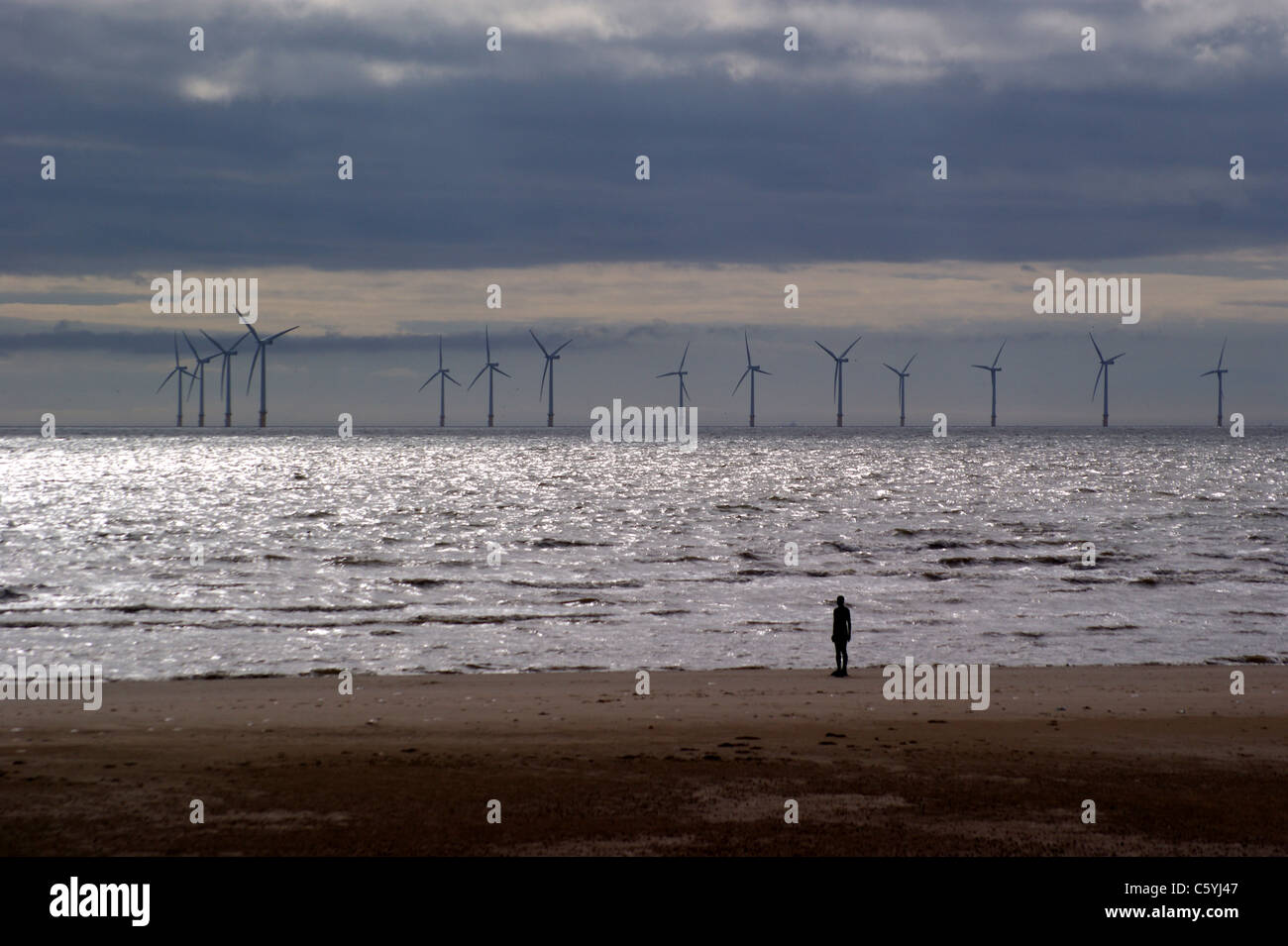 'Another Place', Antony Gormleys Statuen am Crosby Beach, Liverpool, Merseyside, England, Windpark Burbo Bank im Hintergrund Stockfoto