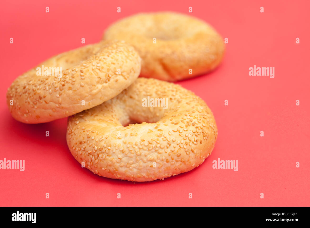 Drei frische Bagels auf einem schönen roten Hintergrund Stockfoto