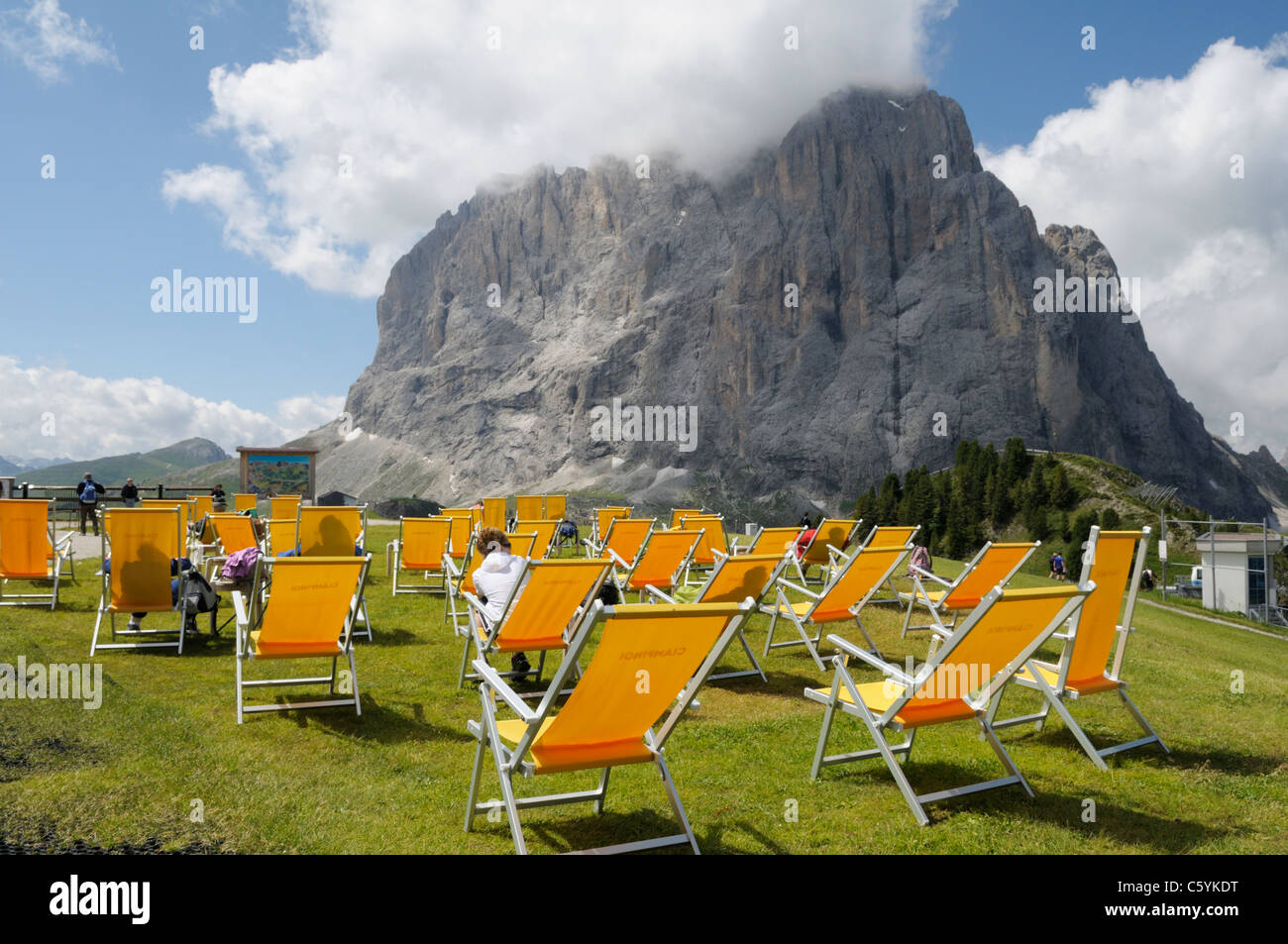 Liegestühle am oberen Rand der Ciampinoi-Seilbahn in der Nähe von Selva Val Gardena, Dolomiten, Italien mit Blick auf den Sasso Lungo Stockfoto
