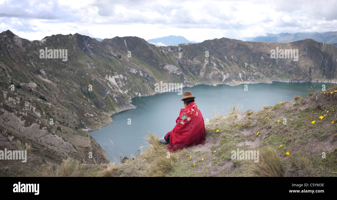 Indigene Frau sitzt am Kraterrand des Vulkans. Stockfoto