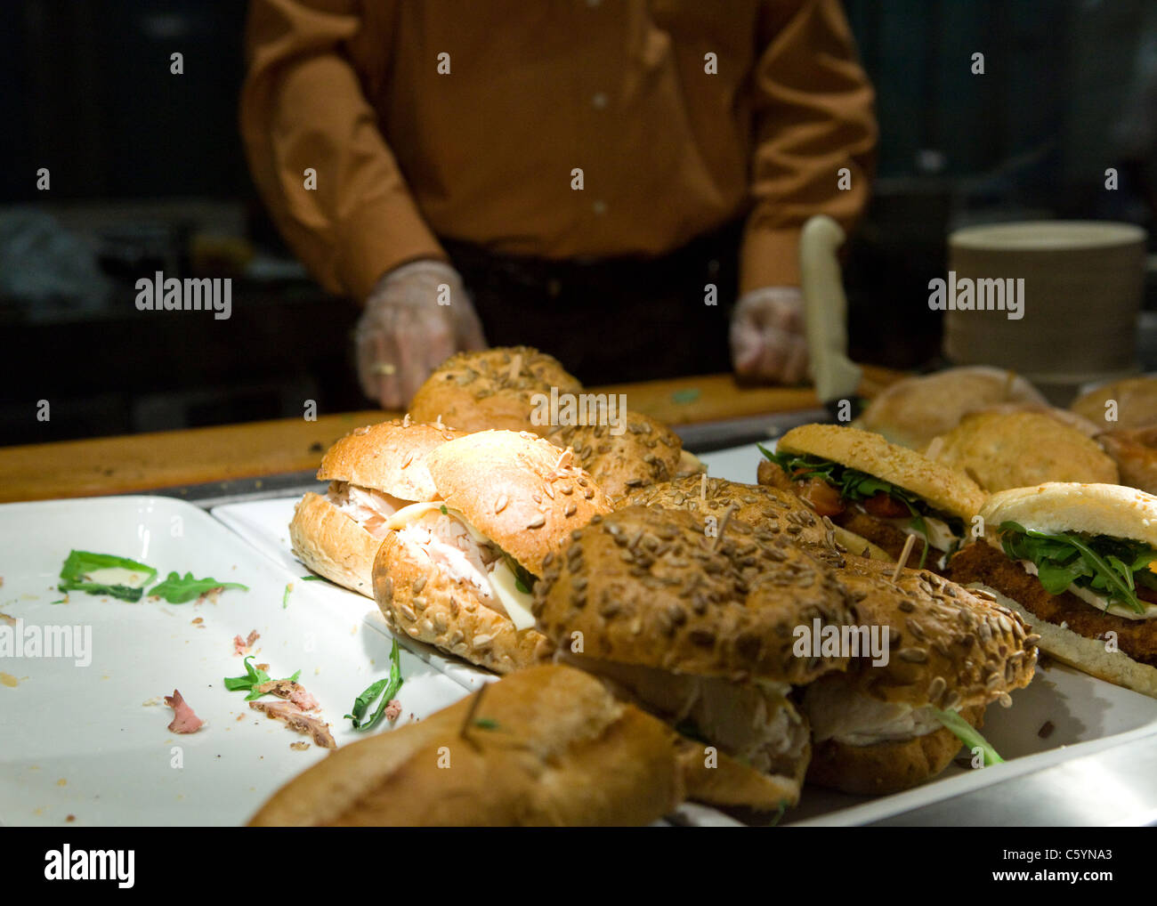 Kochen Sie Vorbereitung Sandwiches hinter Cafeteria Theke Stockfoto