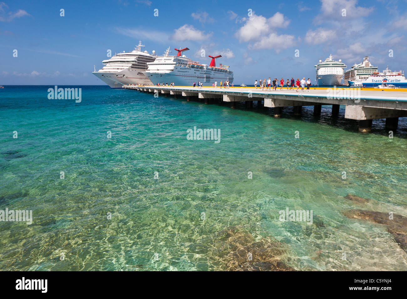 Kreuzfahrtschiffen Sie Passagiere von auf Pier Aussteigen aus Karneval Kreuzfahrt-Schiffe, Triumph und Ekstase in Cozumel, Mexiko Stockfoto