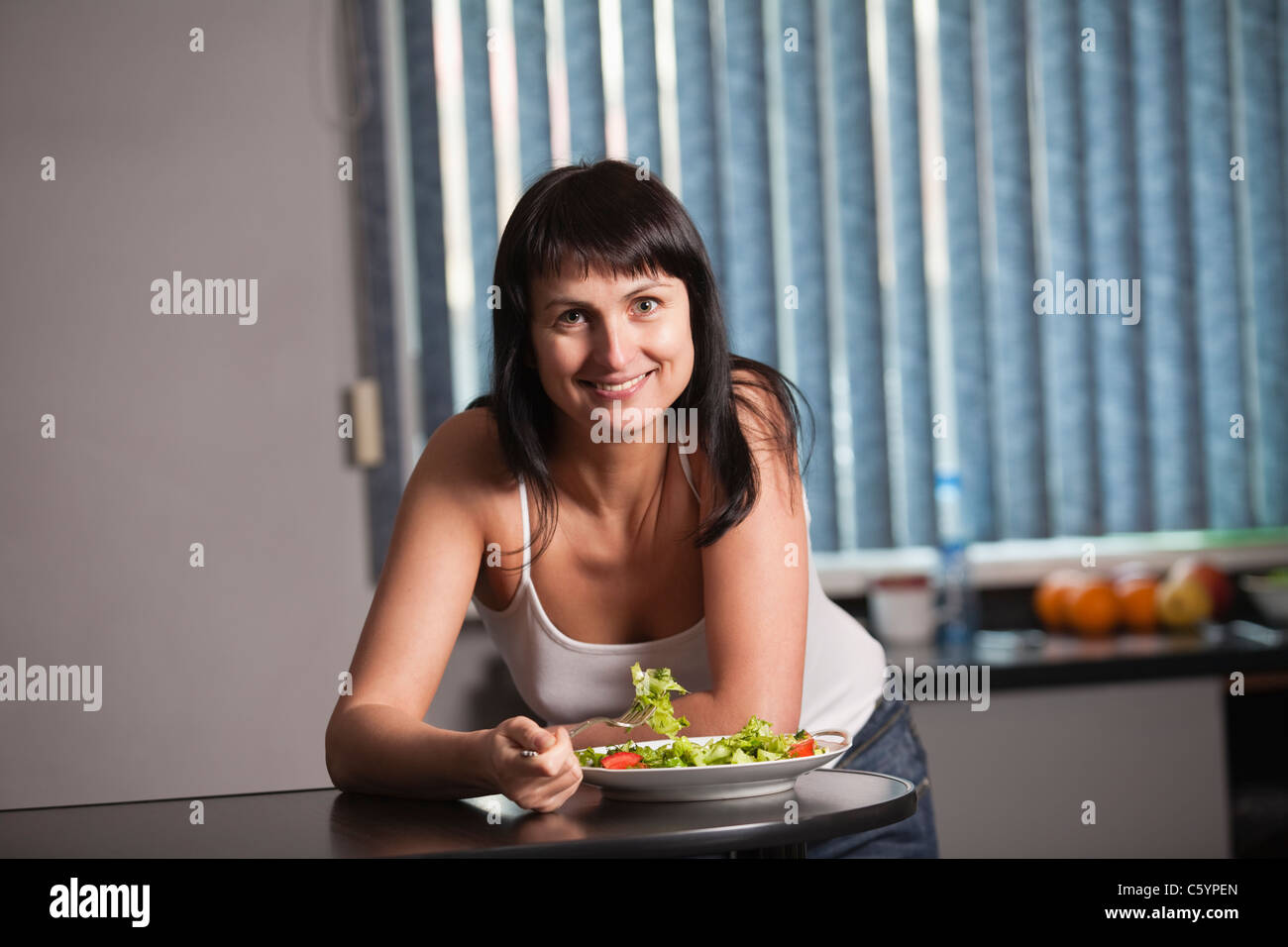 Russland, Voronezh, Frau essen Salat in Küche Stockfoto