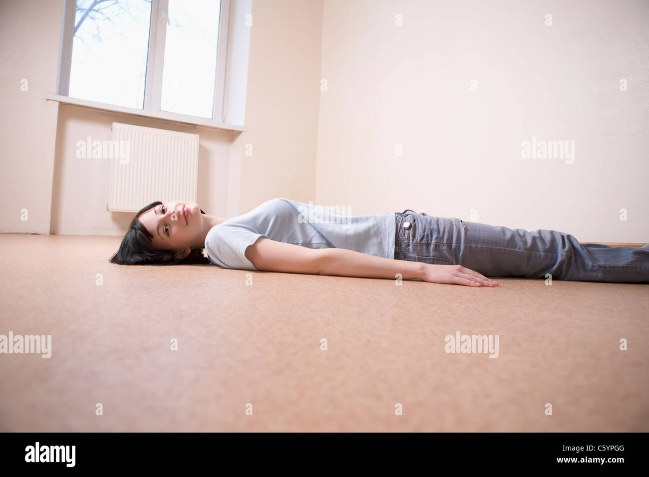 Russland, Voronezh, Frau liegend am Boden im leeren Raum Stockfoto