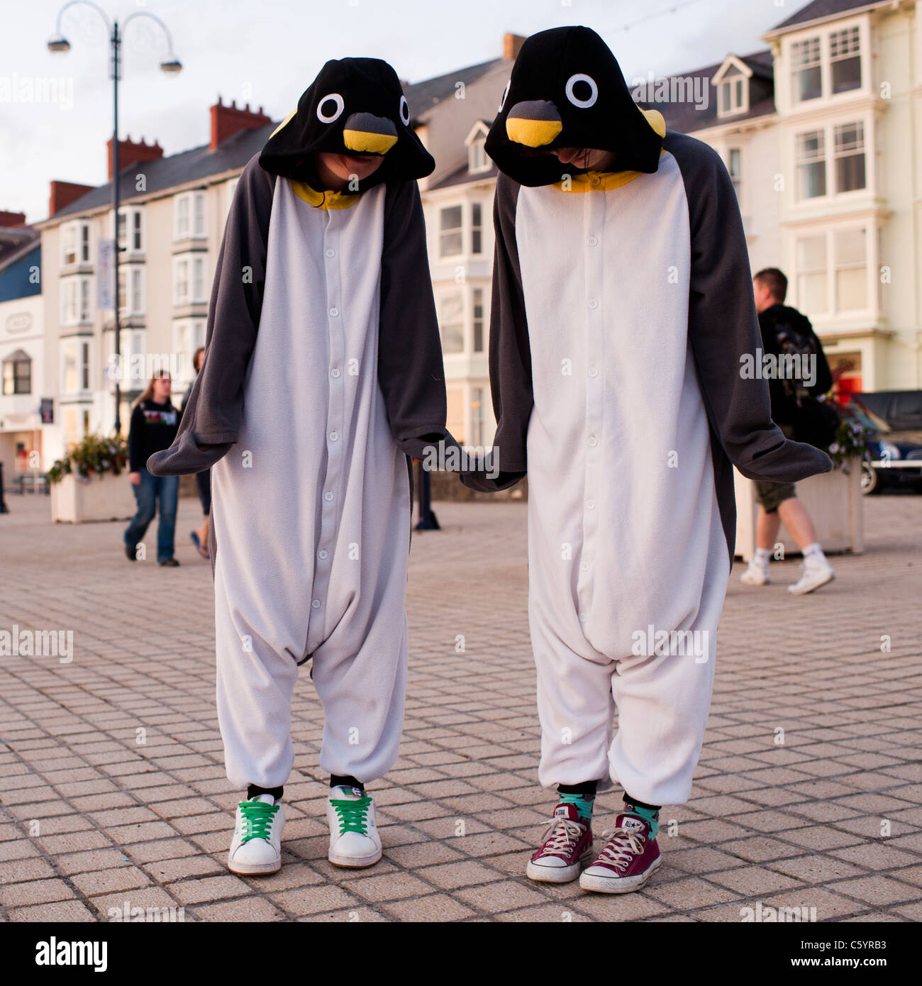 zwei Frauen Mädchen gekleidet wie Pinguine auf Aberystwyth Promenade Wales UK Stockfoto