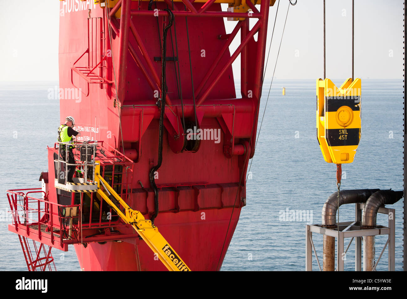 Ein Kranführer auf dem Aufbocken Lastkahn, Kraken, geladen mit Windturbinen für das Walney Offshore-Windpark-Projekt Stockfoto