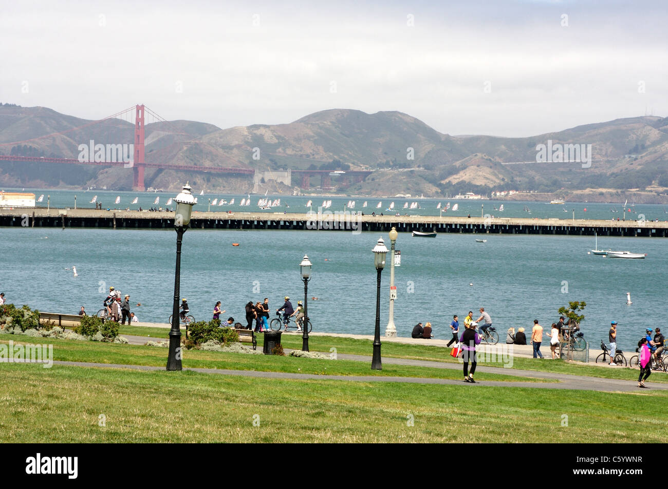 Fußgänger genießen San Francisco Maritime National Historical Park mit der Golden Gate Bridge und die Bucht im Hintergrund Stockfoto
