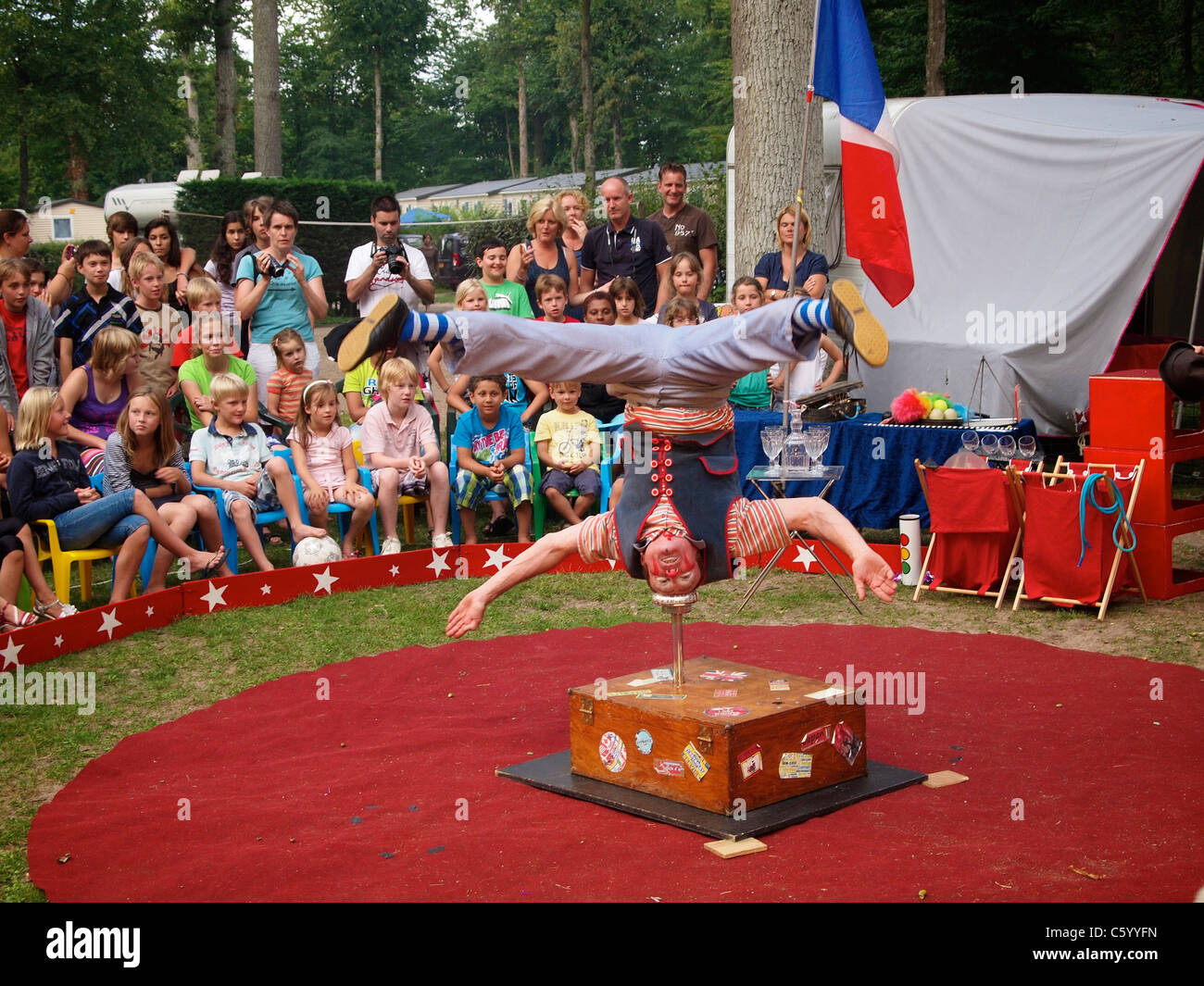 Acrobat in einem sehr kleinen Reisen Zirkus steht auf dem Kopf auf einem Campingplatz in der Nähe von Mer, Loiretal, Frankreich Stockfoto