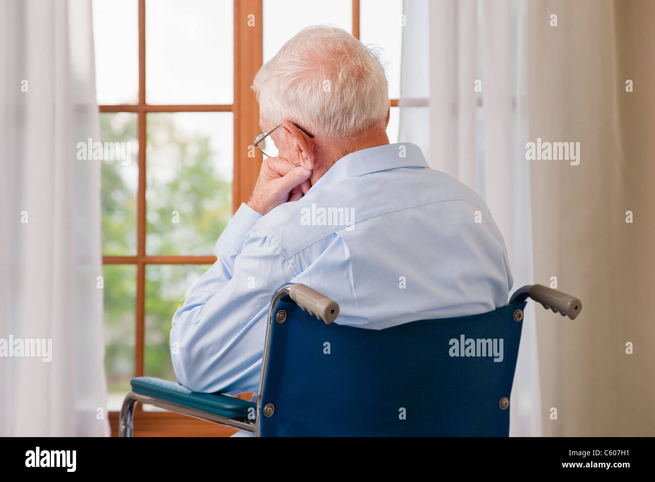 USA, Illinois, Metamora, Rückansicht des älteren Menschen am Rollstuhl ruht vor Fenster Stockfoto