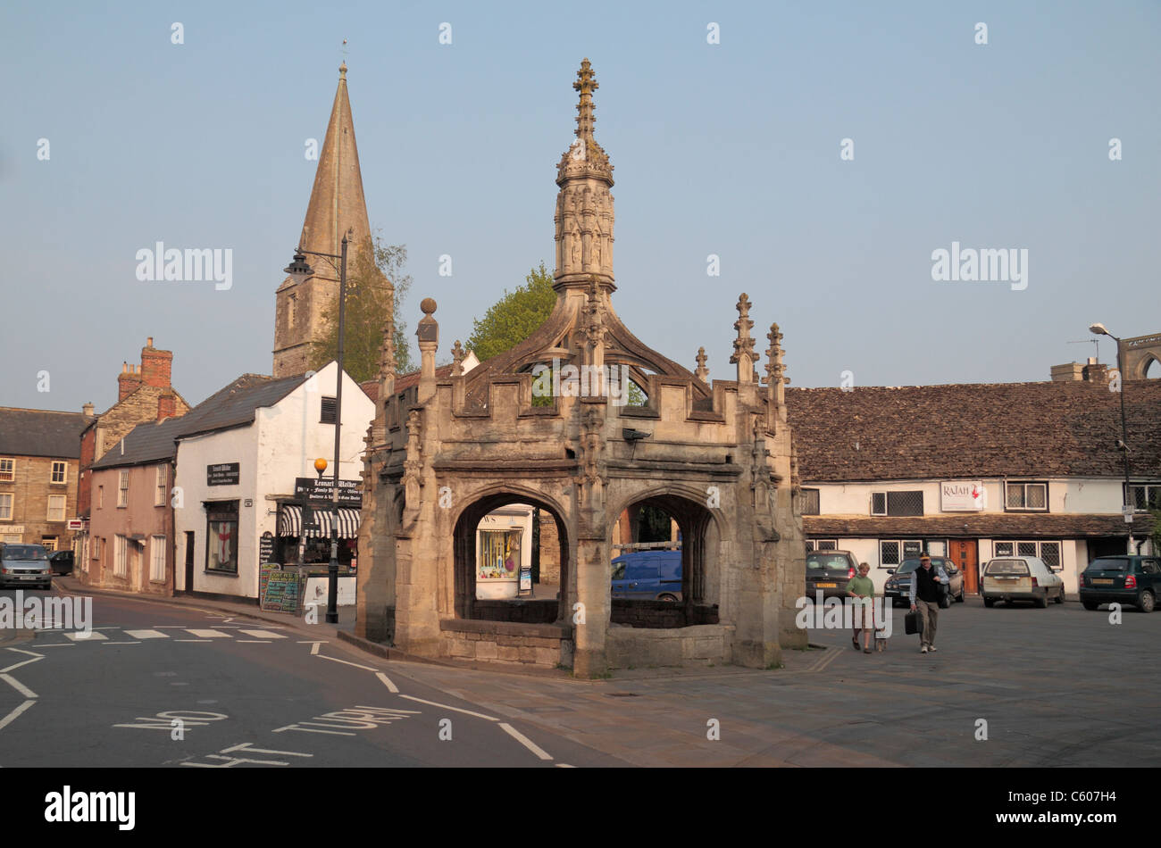 Markt Kreuz mit Malmesbury Abbey hinter in Malmesbury, Cotswolds, Wiltshire, England. Stockfoto