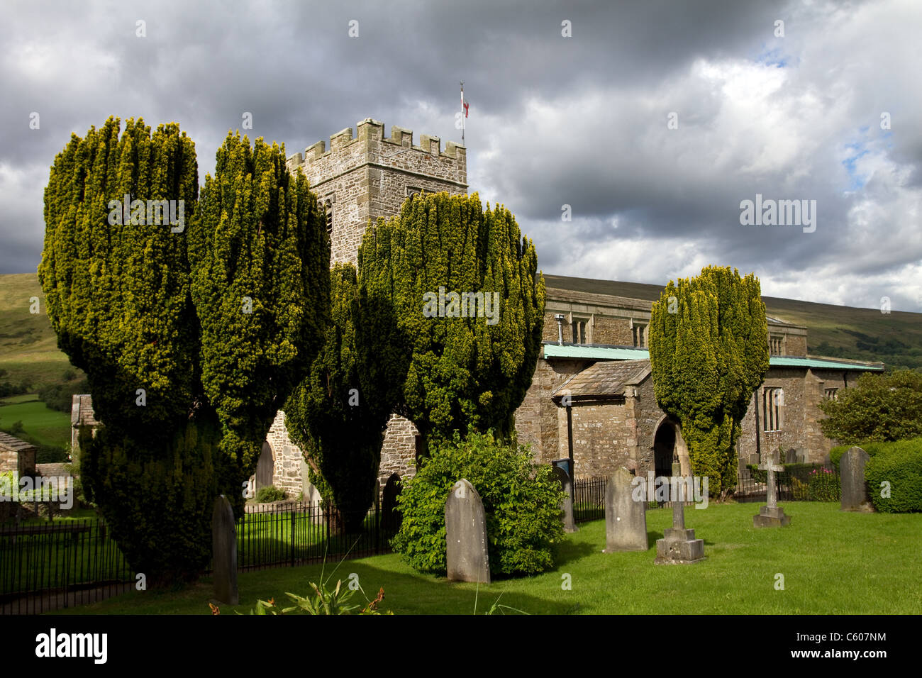Wind geblasen Eiben  12th Jahrhundert Kirche von Str. Andrew Dent   Dentdale, Yorkshire Dales National Park, UK Stockfoto
