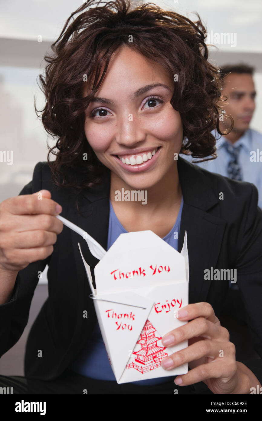 USA, New York, New York City, Porträt der lächelnde junge Frau Essen Chinise Essen Stockfoto