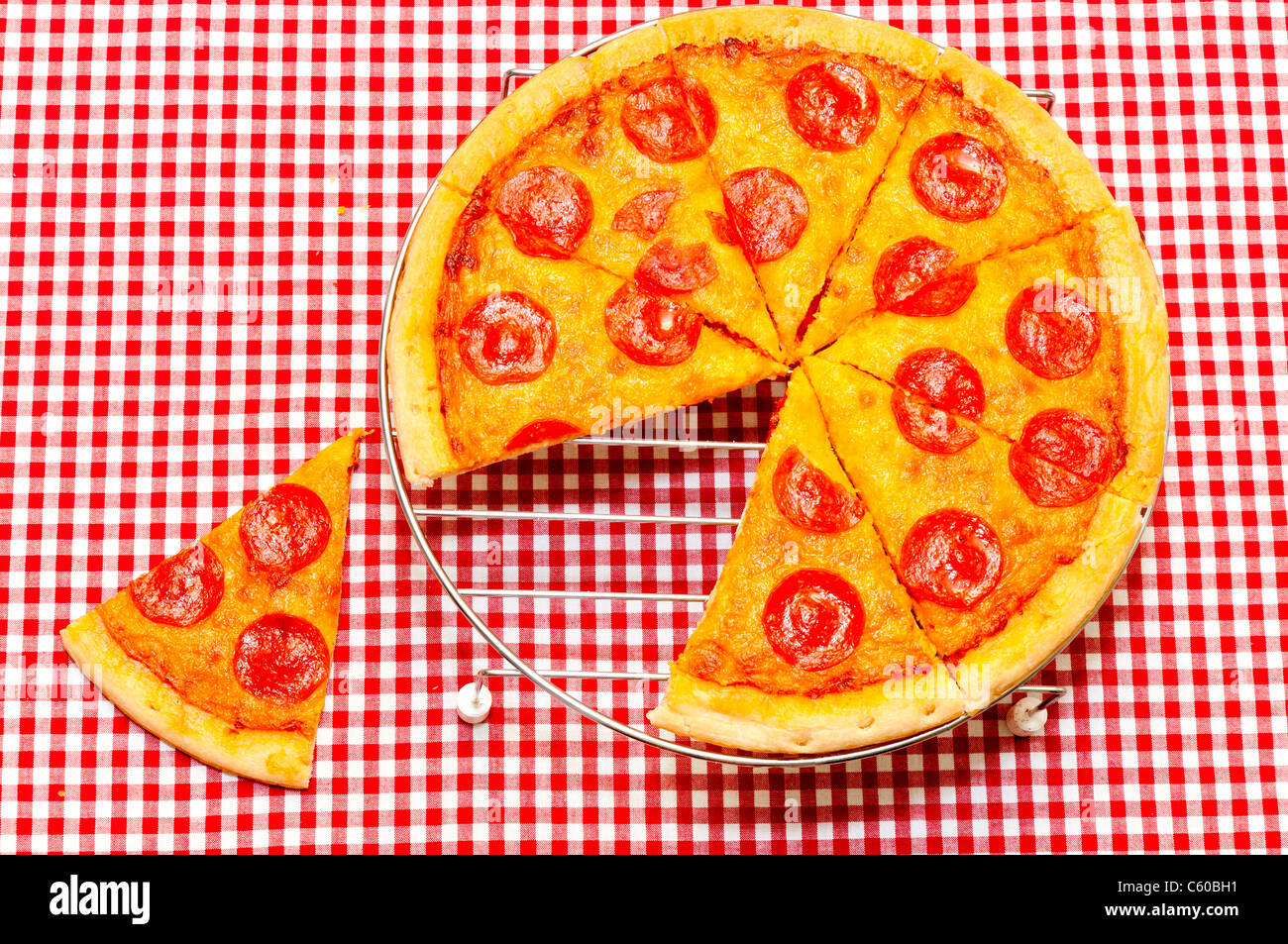 Ganze Peperoni-Pizza mit Scheibe entfernt Stockfoto