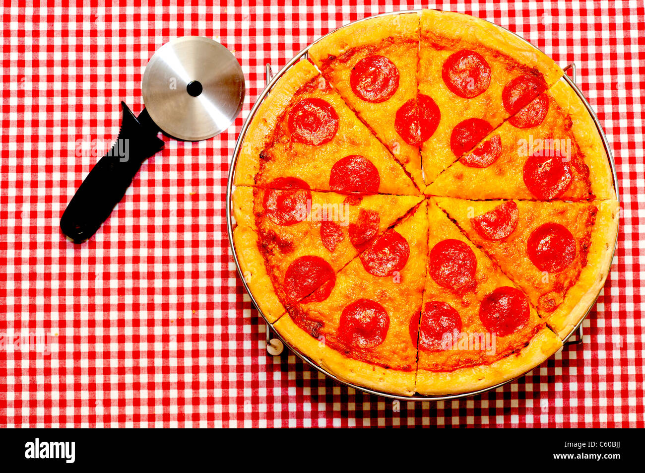 In Scheiben geschnitten ganze Peperoni-Pizza mit Cutter Stockfoto