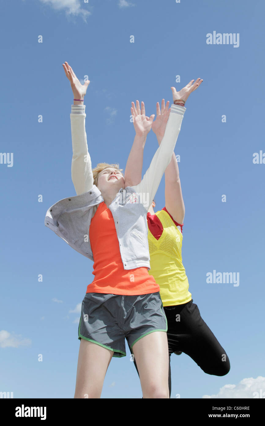 Mädchen springen vor Freude gegen blauen Himmel Stockfoto