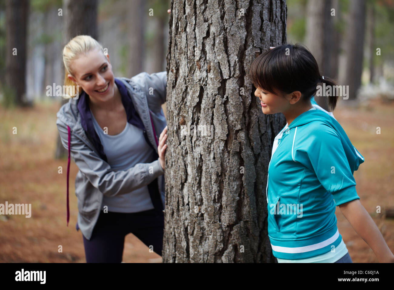 Frauen stützte sich auf Baum im Wald Stockfoto