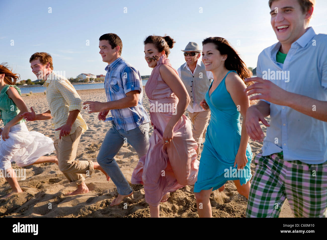 Menschen, die zusammen am Strand laufen Stockfoto