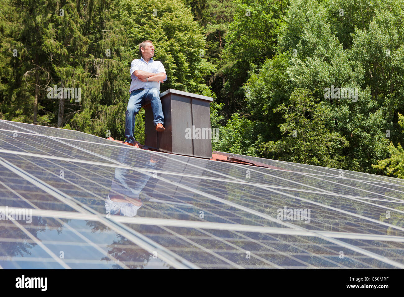 Mann auf getäfelten Solardach Stockfoto