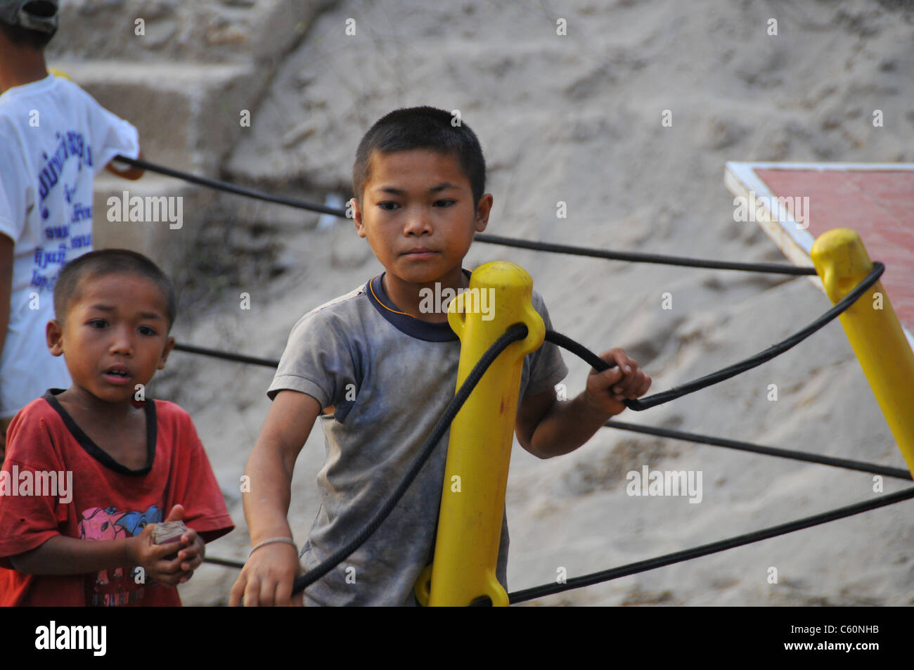 zwei jungen warten auf die Fähre auf dem Mekong in Laos Stockfoto