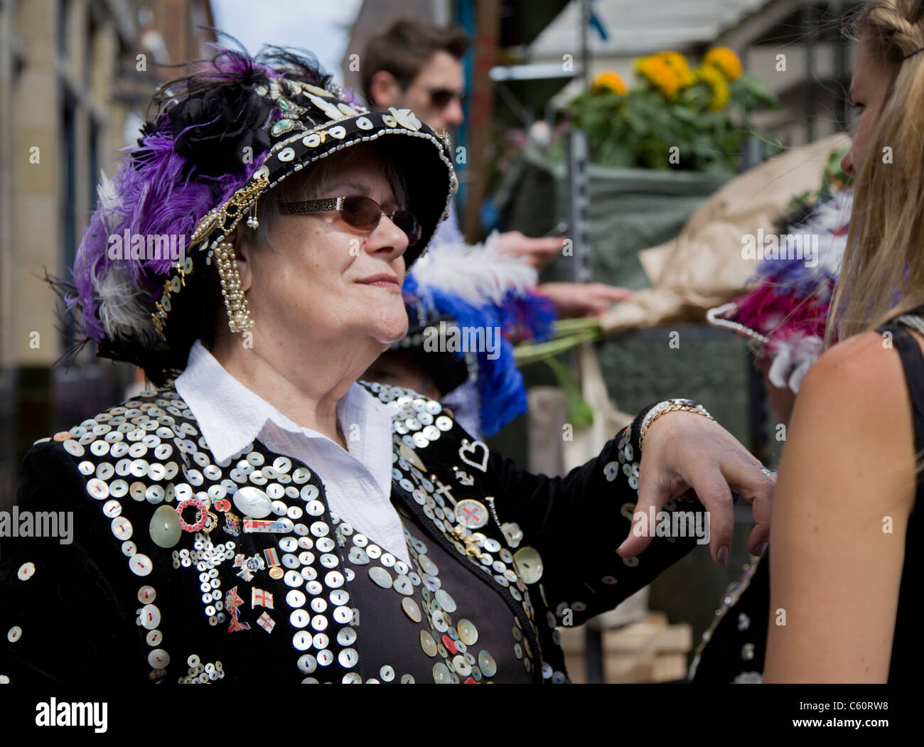 Pearly Queen tragen lila Feder in ihrem Hut an Columbia Street Flower Market Stockfoto