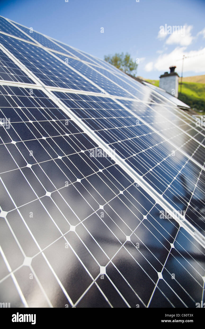 Solar Strom (Photovoltaik) und Solarthermie (Warmwasser) Panels auf einem Hausdach in Grasmere, Lake District, Großbritannien. Stockfoto