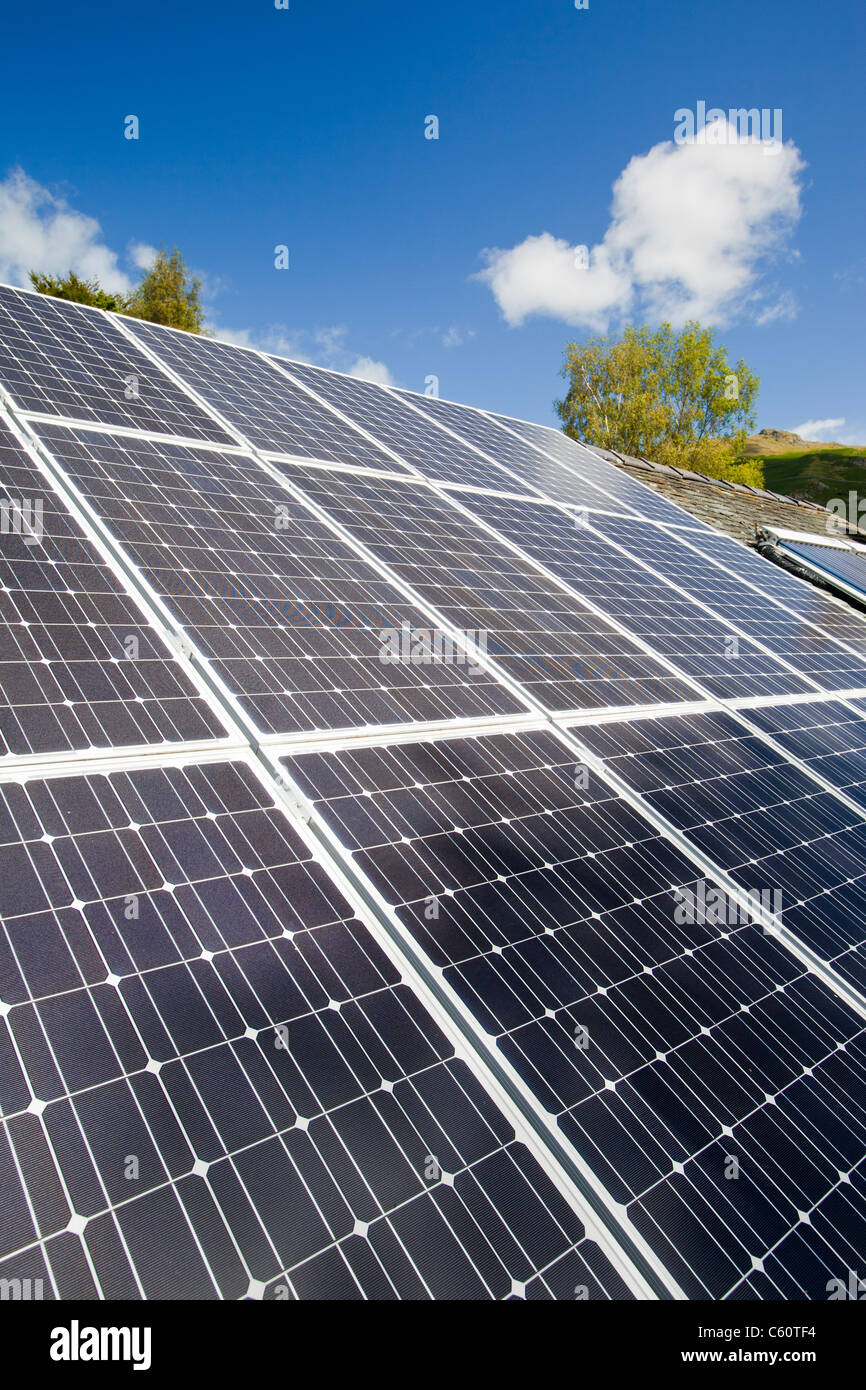 Solar Strom (Photovoltaik) und Solarthermie (Warmwasser) Panels auf einem Hausdach in Grasmere, Lake District, Großbritannien. Stockfoto