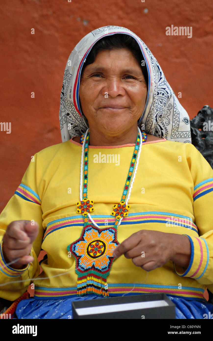 Ein Huichol Mexikanerin arbeiten an ihren handgefertigten Schmuck. Stockfoto