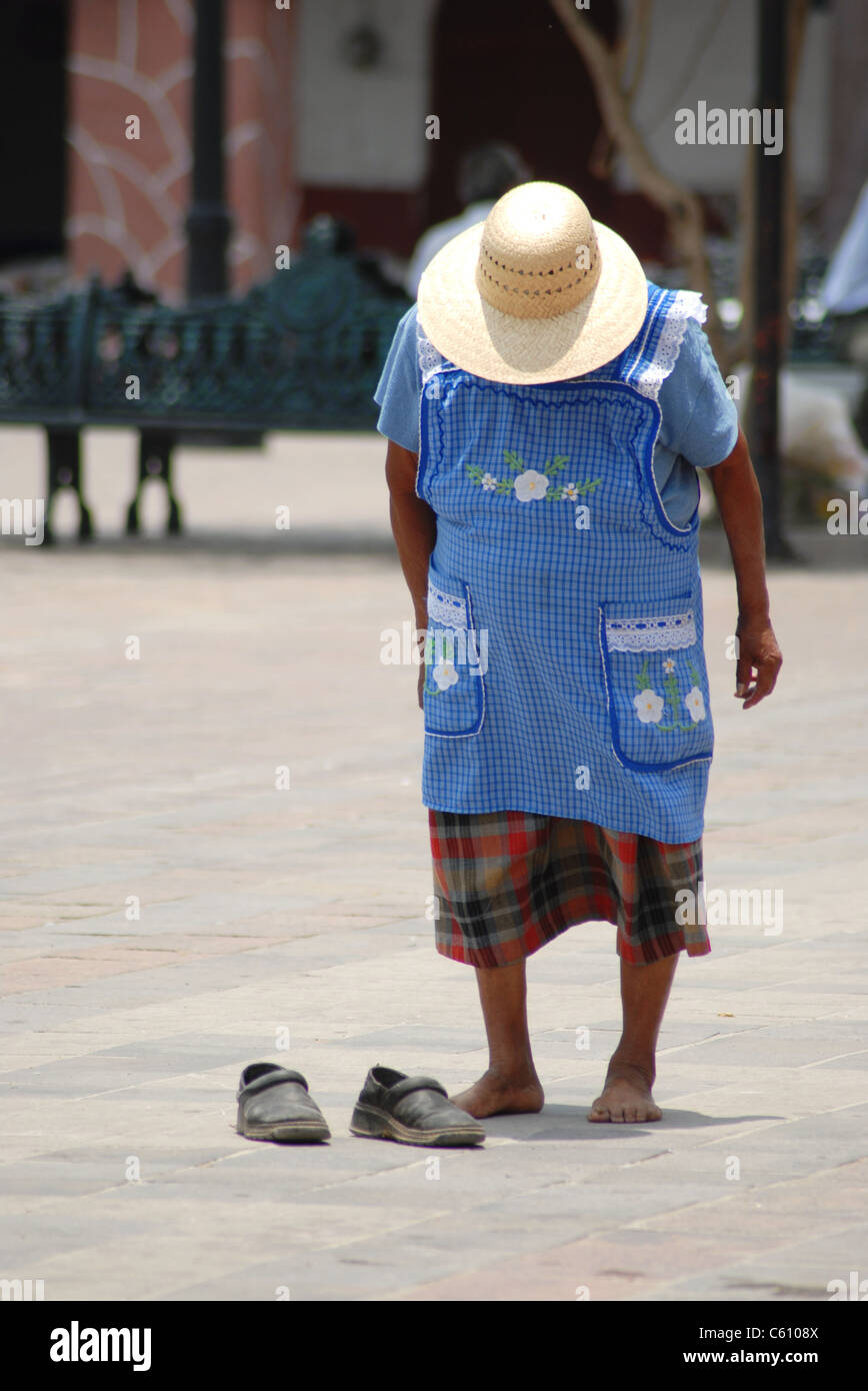 Eine alte mexikanische Frau schaut Schuhe. Stockfoto