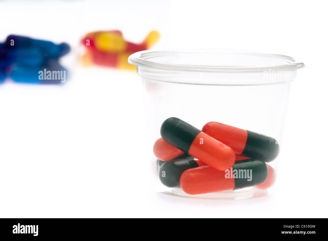 Bunte Tabletten, Kapseln in einem Behälter über weiß Stockfoto