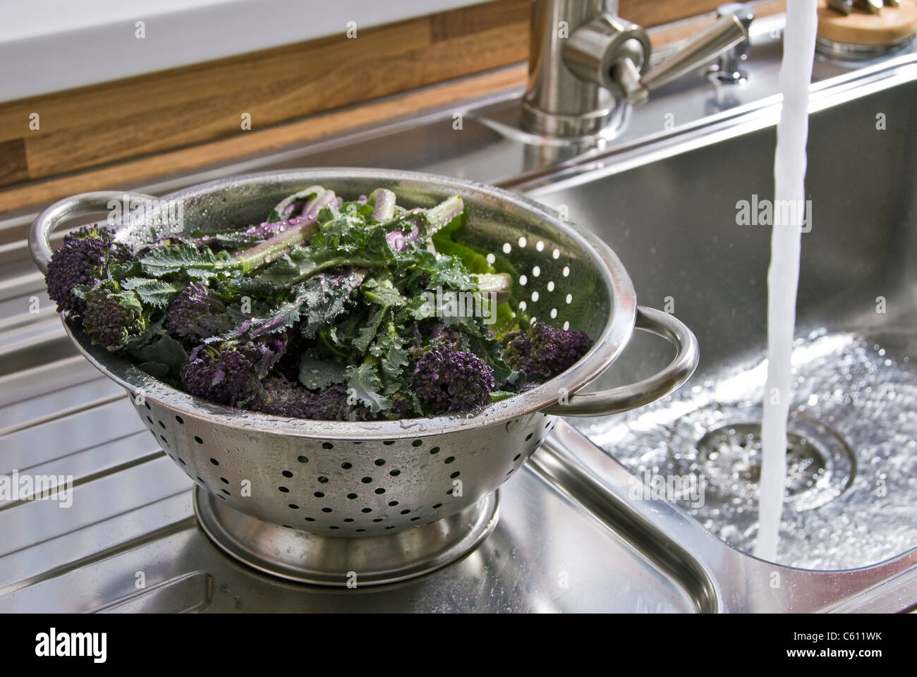 Waschen Gemüse in einem Edelstahl-Sieb. Stockfoto