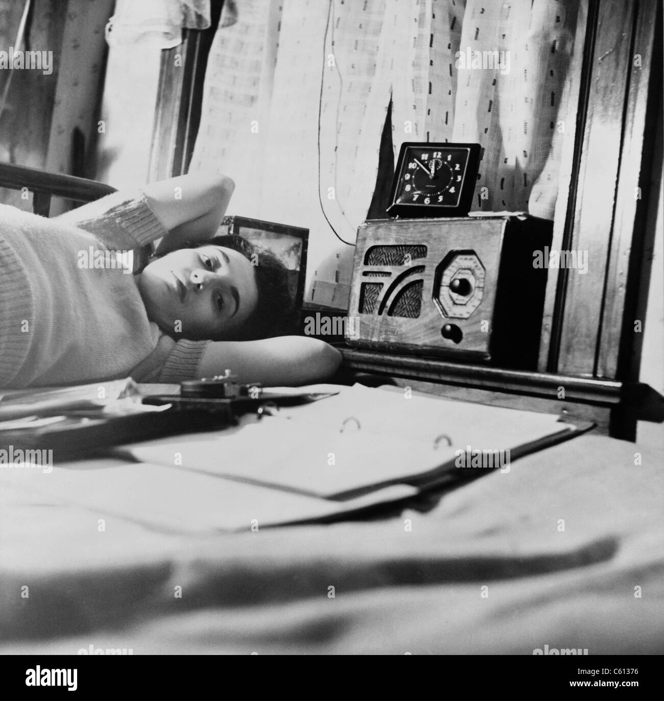 Eine junge Frau hört ein Radio in ihrem Washington D.C. Boardinghouse-Zimmer. 1943. Stockfoto